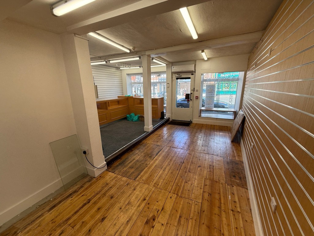 Lot: 37 - COMMERCIAL PROPERTY WITH SELF-CONTAINED SPLIT LEVEL FLAT ABOVE - view of the shop from the back looking towards the entrance